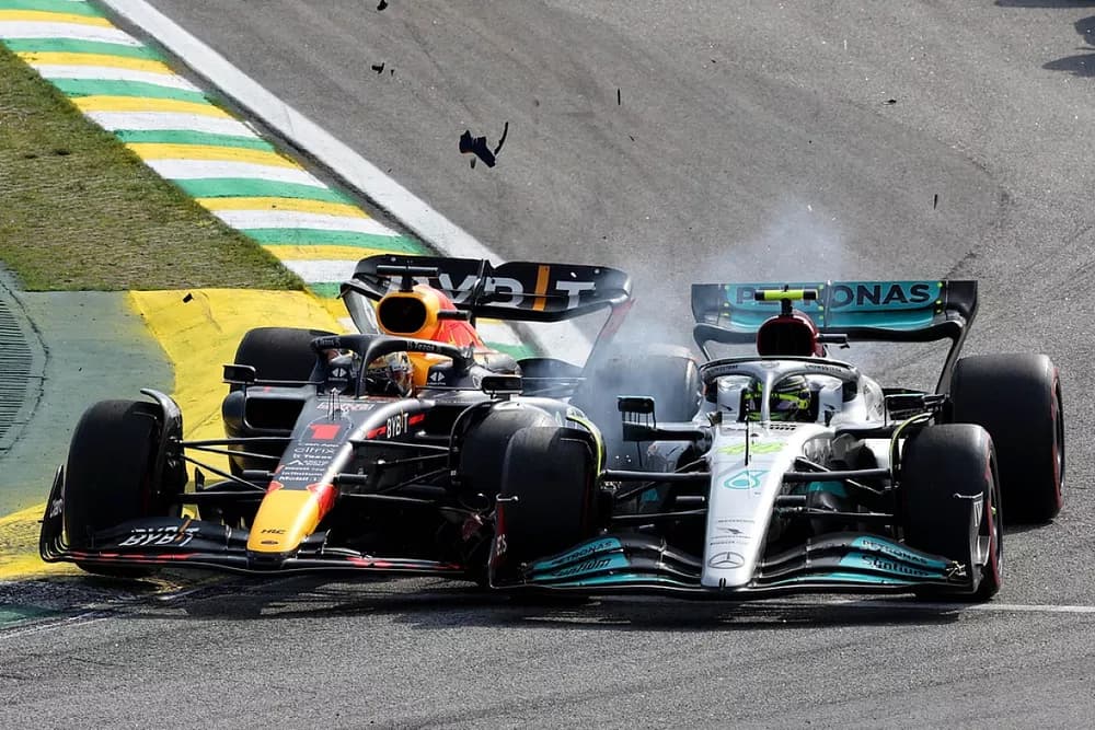 Max Verstappen's Red Bull and Lewis Hamilton's Mercedes in contact on track, with debris in the air