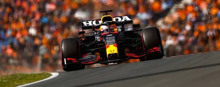 Max Verstappen racing at Zandvoort in front of orange-clad spectators